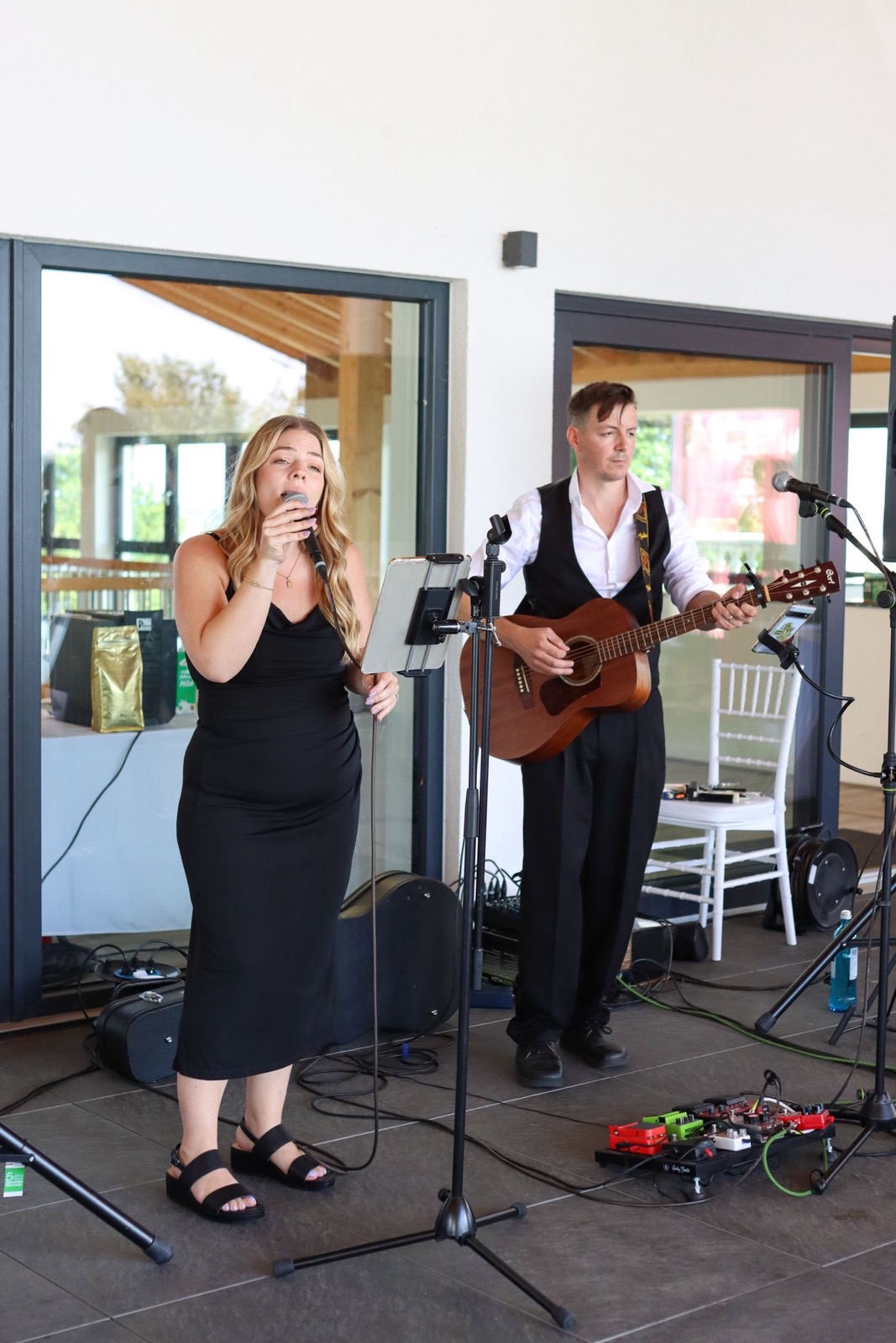 Brittany and Diet with acoustic guitar at a bright wedding venue
